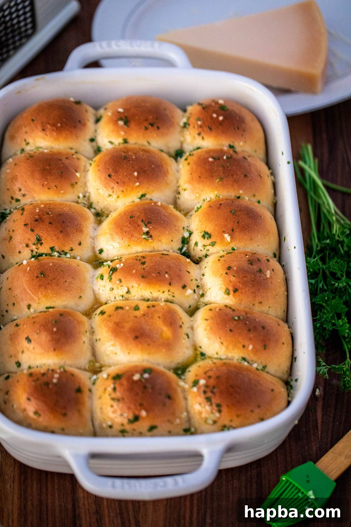 A complete baking dish of garlic butter dinner rolls, glistening with the butter topping and ready to be served.