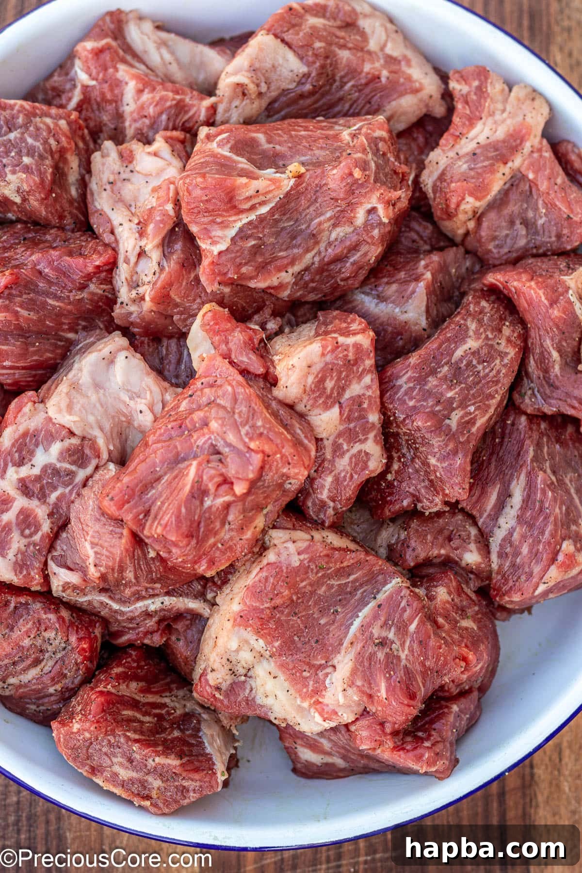 Non-Alcoholic Beef Stew 6 Perfectly seasoned beef chunks ready for browning in a white bowl.