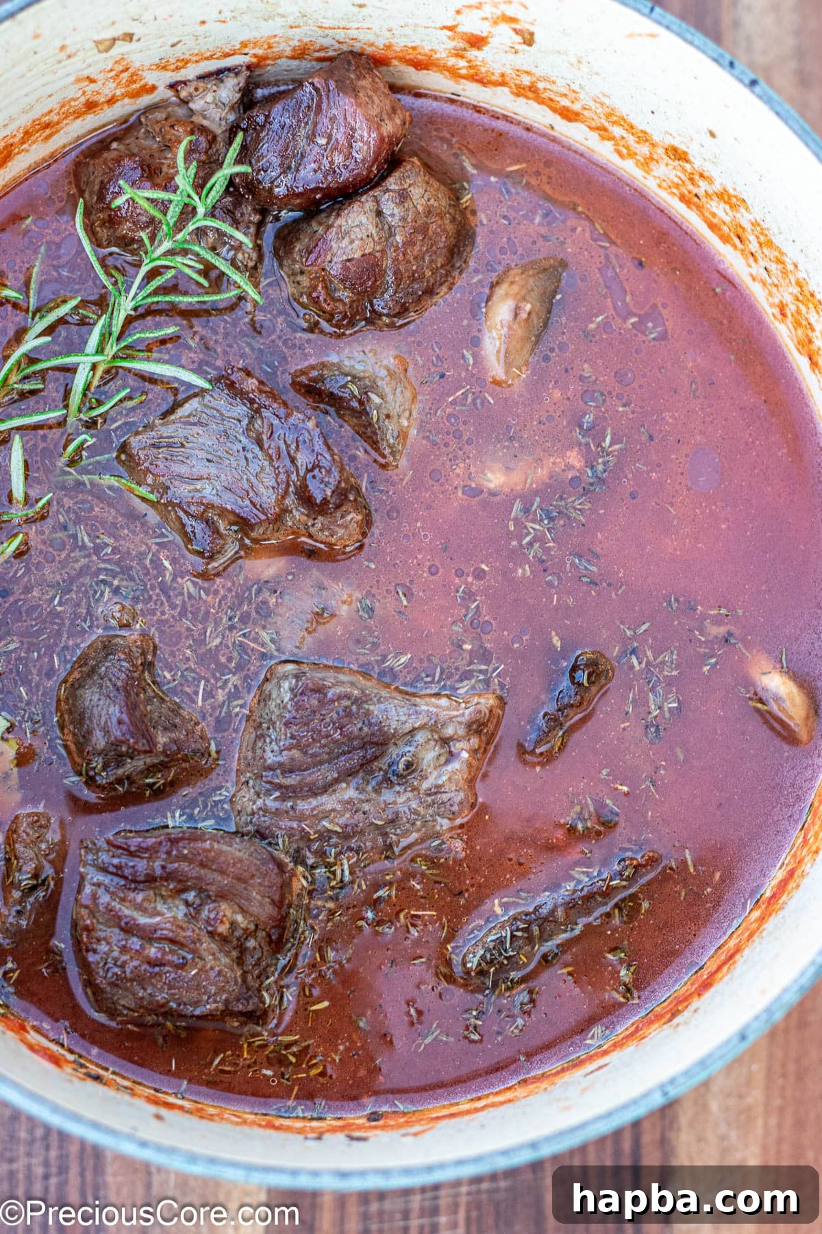 Non-Alcoholic Beef Stew 9 Dutch oven filled with beef, broth, and crushed tomatoes, ready for simmering.