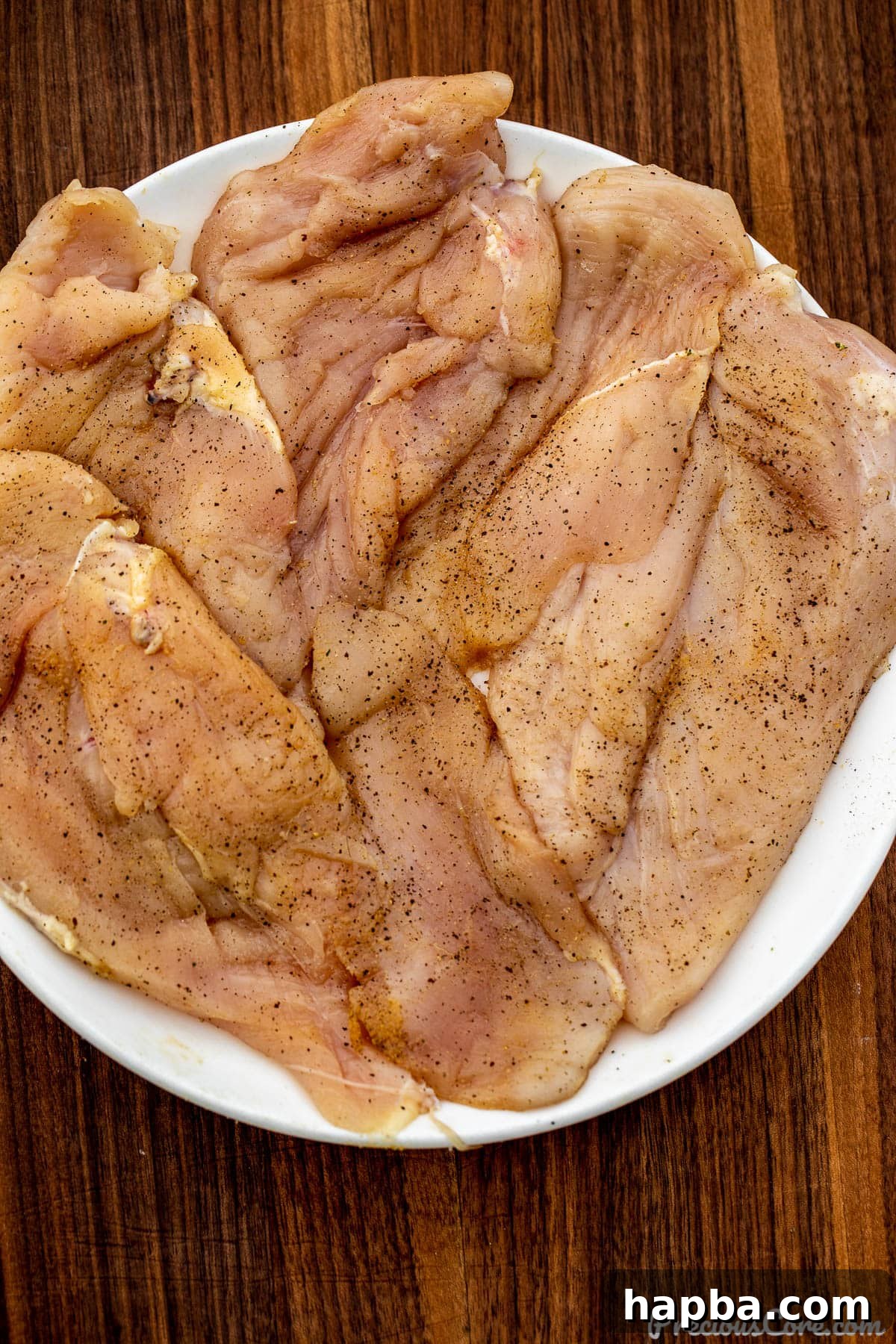 Seasoned chicken breasts on a plate.