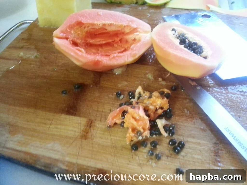 A papaya half with seeds removed, showing its smooth, vibrant orange flesh, ready to be sliced for the fruit salad.