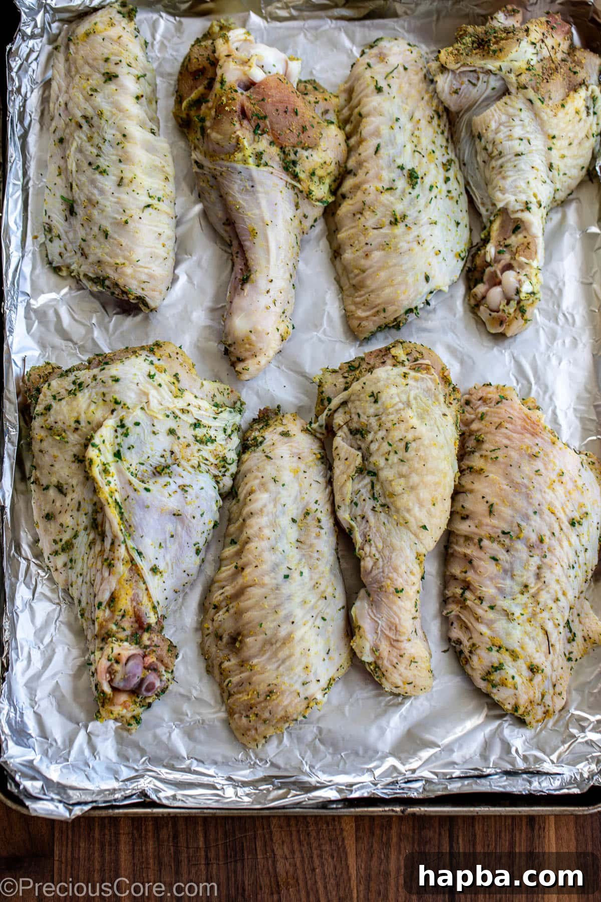 Seasoned turkey wings on a baking sheet.