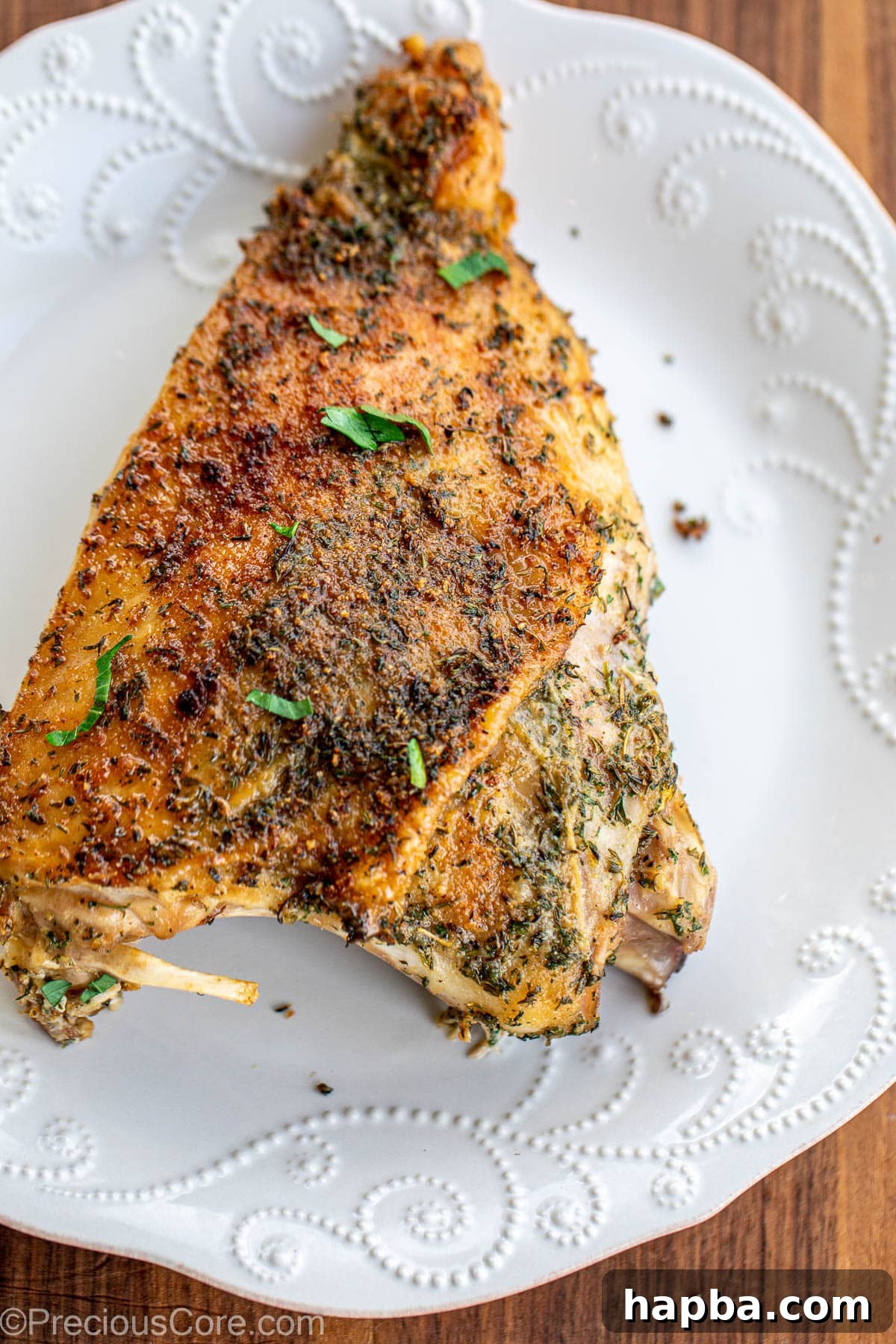 A large roasted turkey thigh on a plate, garnished and ready to serve.