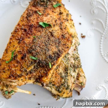 A large roasted turkey thigh on a plate.