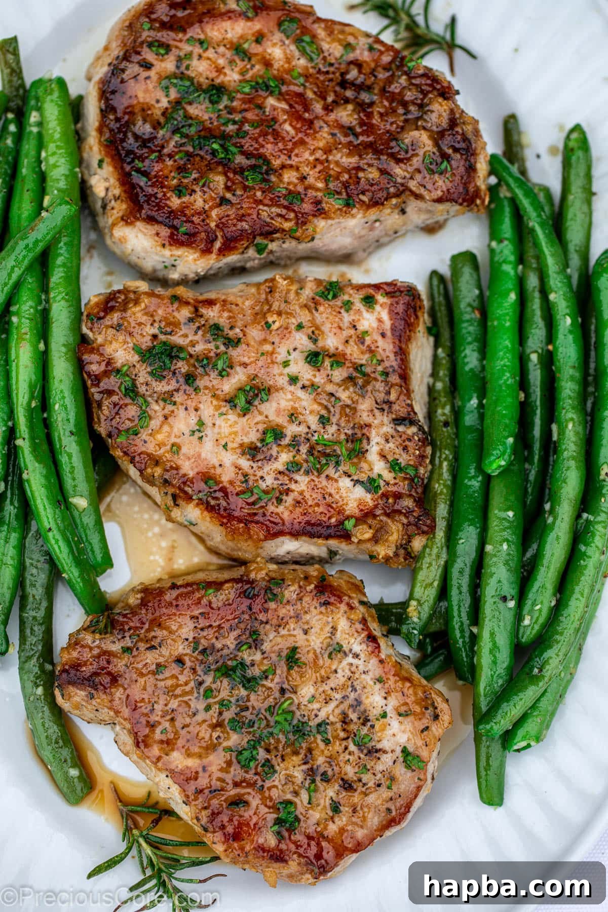 Pork Chops served in a pan alongside a generous portion of garlic butter green beans.