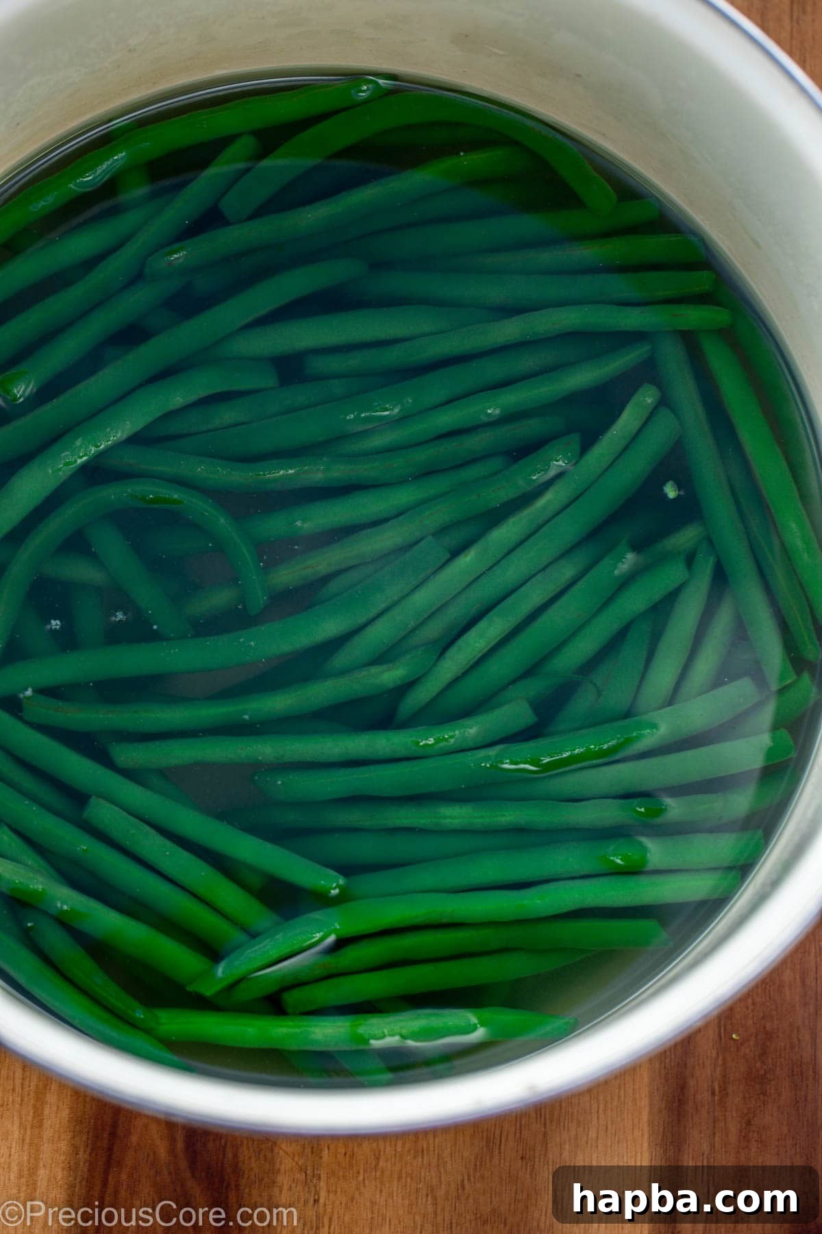 Fresh green beans in a pot of hot, boiling water.