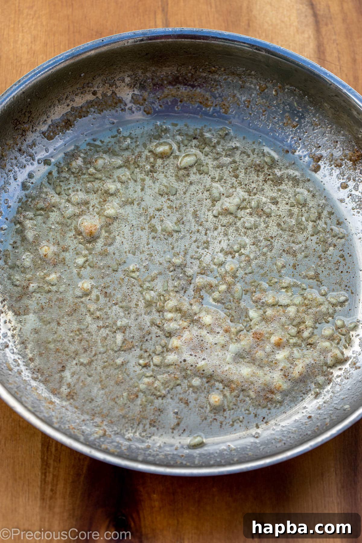 Minced garlic and melted butter sizzling in a skillet.