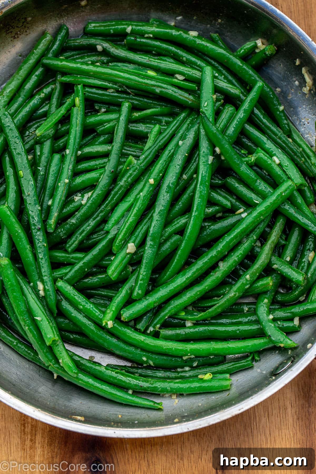 Green beans tossed in a skillet with garlic and butter.