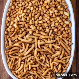 Crispy, golden Chin Chin pieces scattered on a white serving tray, ready to be enjoyed.