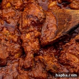 A vibrant red tomato chicken stew, representative of many delicious African dinner recipes featured in the collection.