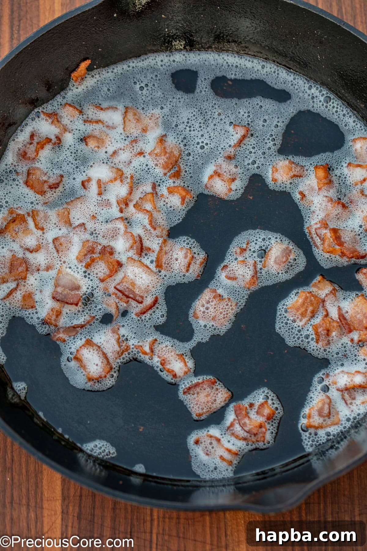 Caramelized Brussels Sprouts with Crispy Bacon 7 Browned bacon bits in bacon grease in a skillet.