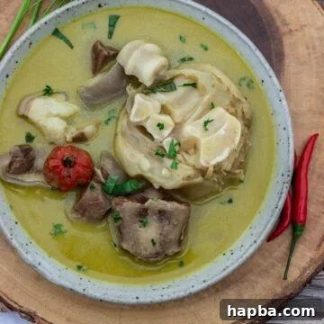 Bowl of pepper soup sitting on a round platter.