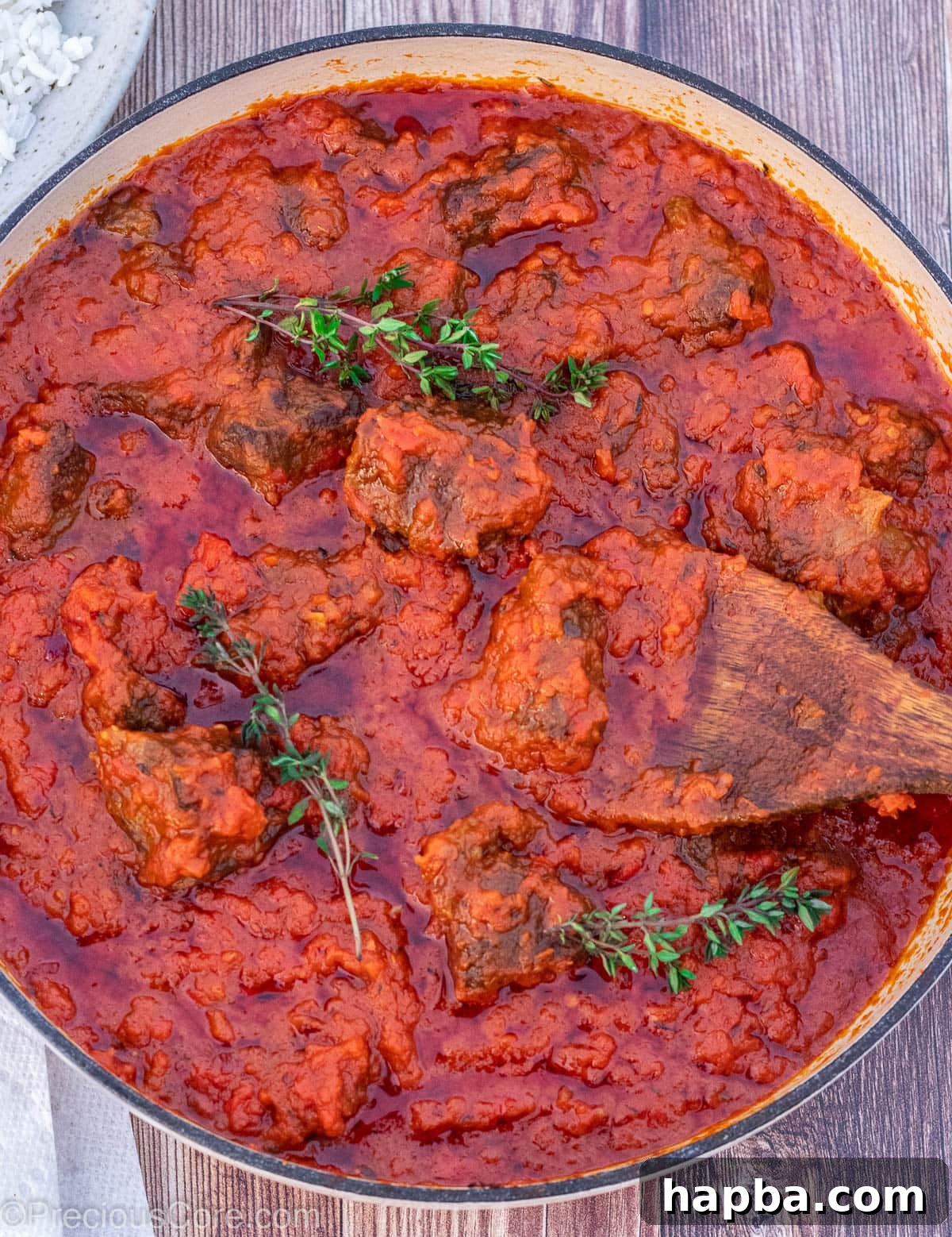A shallow pot filled with the vibrant, finished Nigerian Beef Stew, rich with tender beef chunks and a savory sauce.
