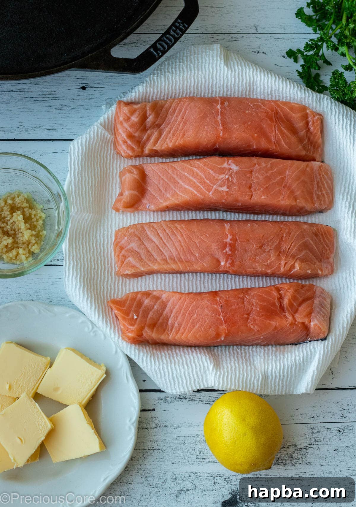 Zesty Lemon Butter Salmon 3 Raw salmon, minced garlic, butter, and lemon on a board.
