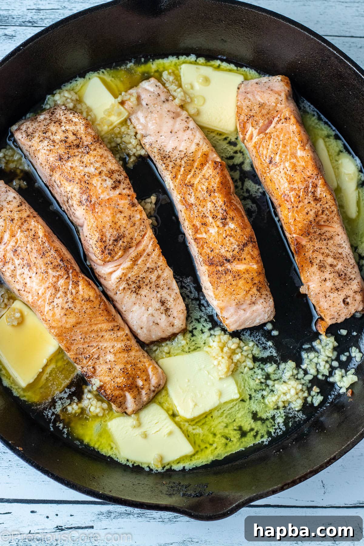 Zesty Lemon Butter Salmon 6 Butter and minced garlic in a cast iron skillet with seared salmon.