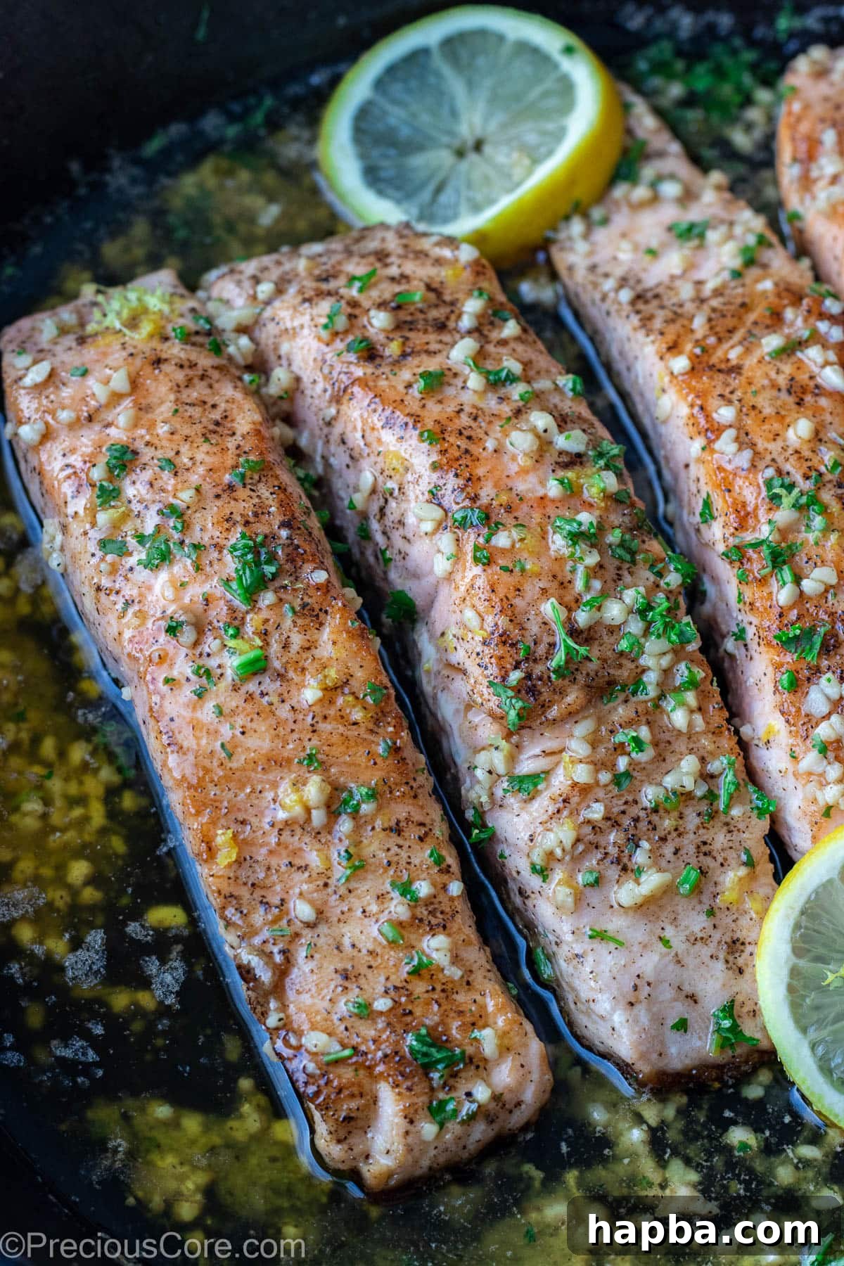 Zesty Lemon Butter Salmon 7 Lemon butter salmon in pan garnished with parsley and lemon slices.