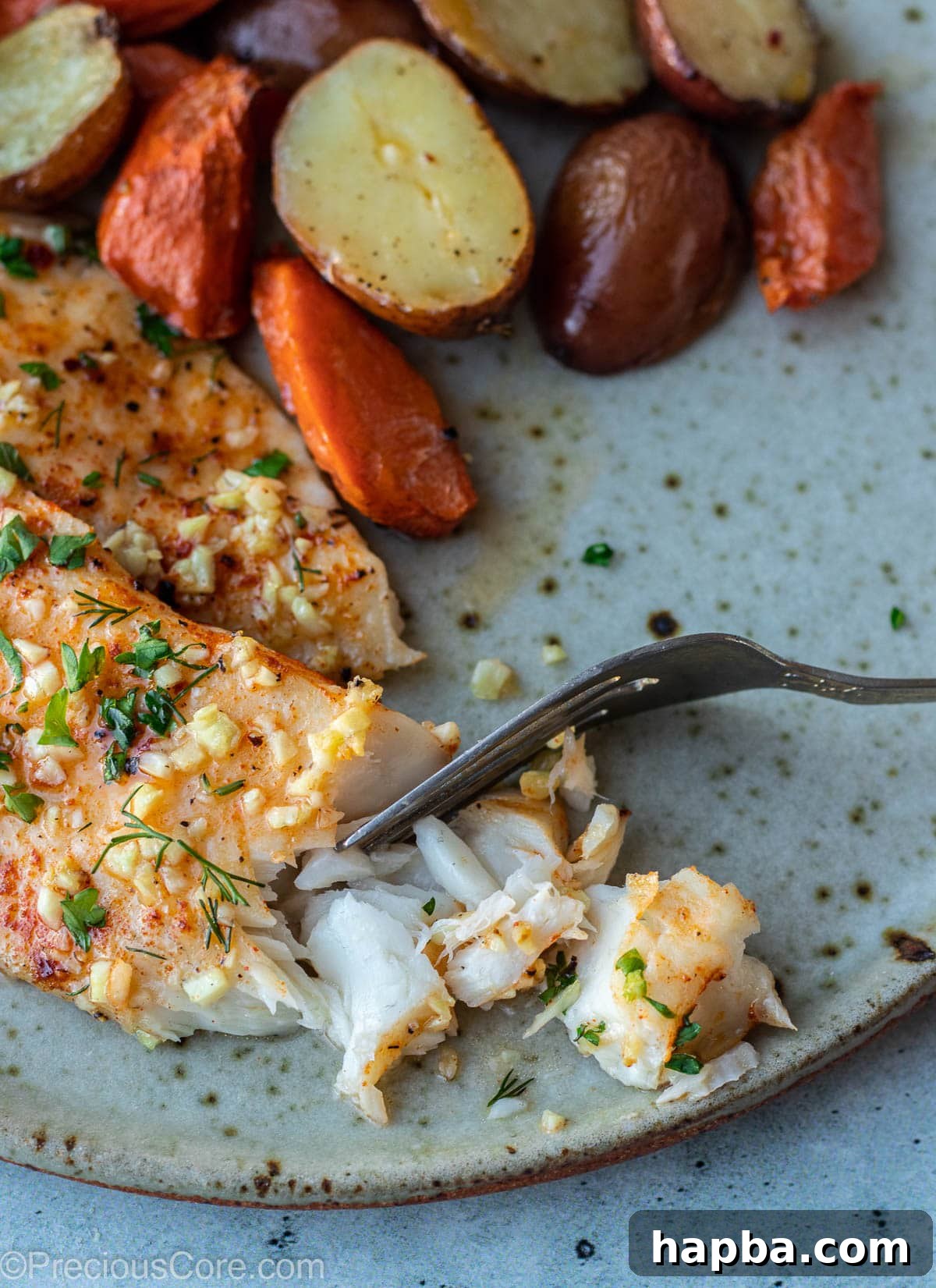 A close-up of flaky, perfectly cooked fish on a plate, showcasing its tender texture.