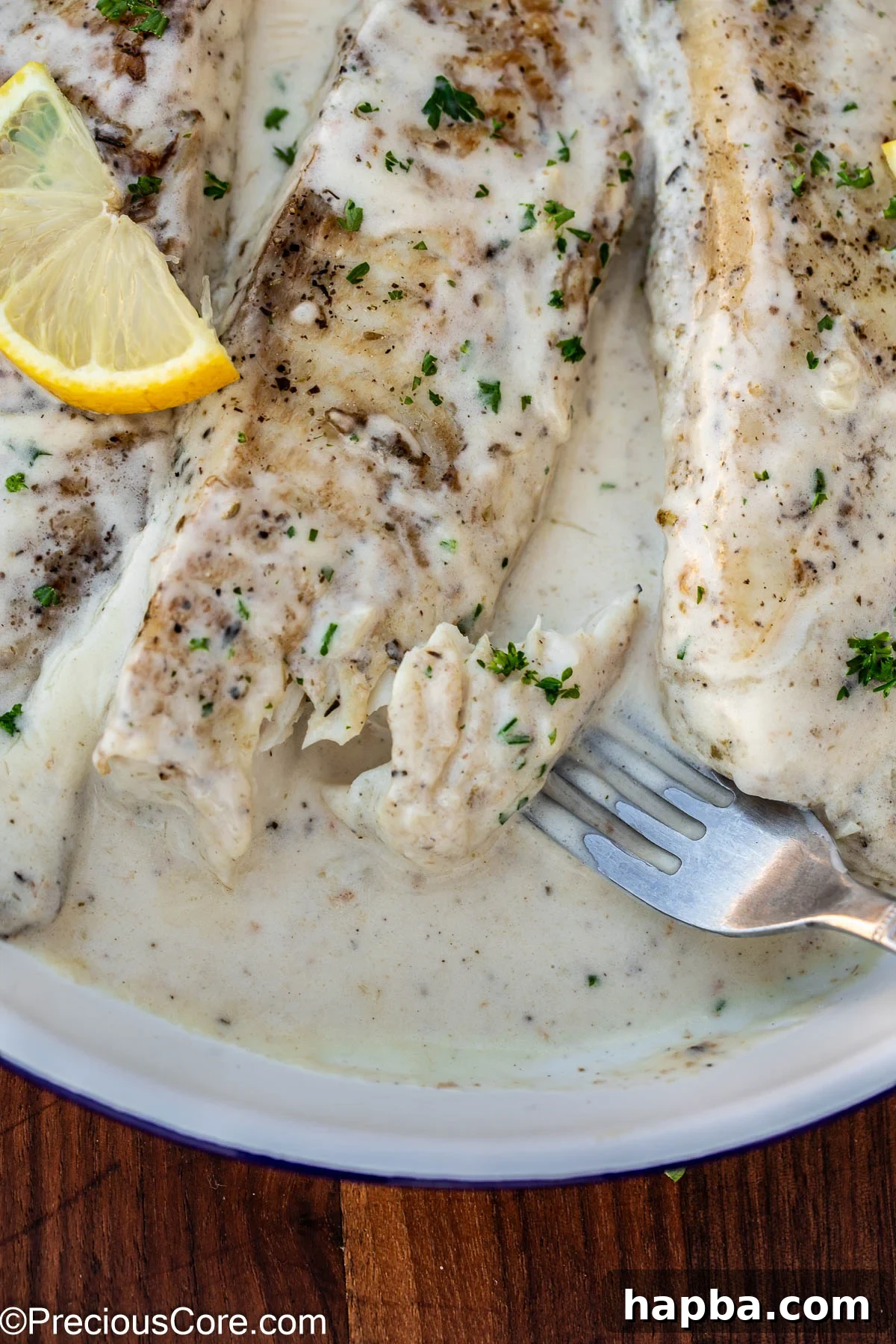 Creamy White Sauce Fish 13 A fork gently separating cooked fish, demonstrating its perfect flakiness and tenderness.
