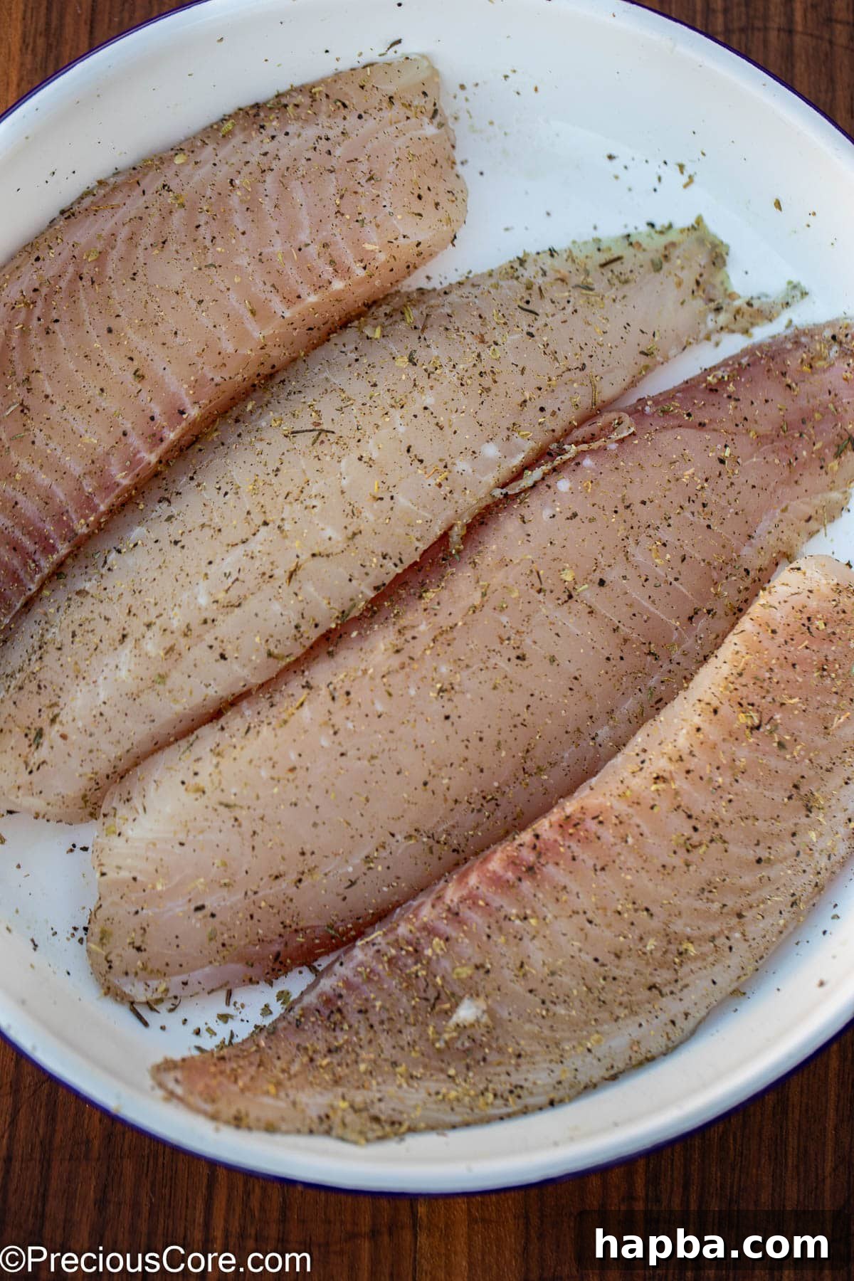 Creamy White Sauce Fish 5 Raw tilapia fillets, seasoned generously with salt, pepper, and Italian seasoning.