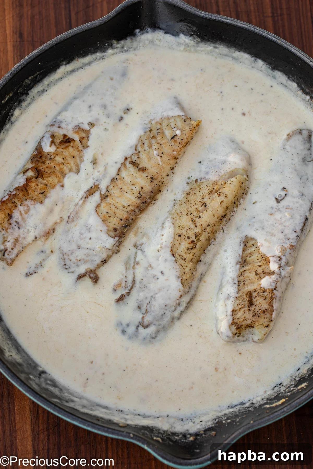 Creamy White Sauce Fish 10 Fish fillets simmering gently in the creamy white sauce, absorbing all the flavors.