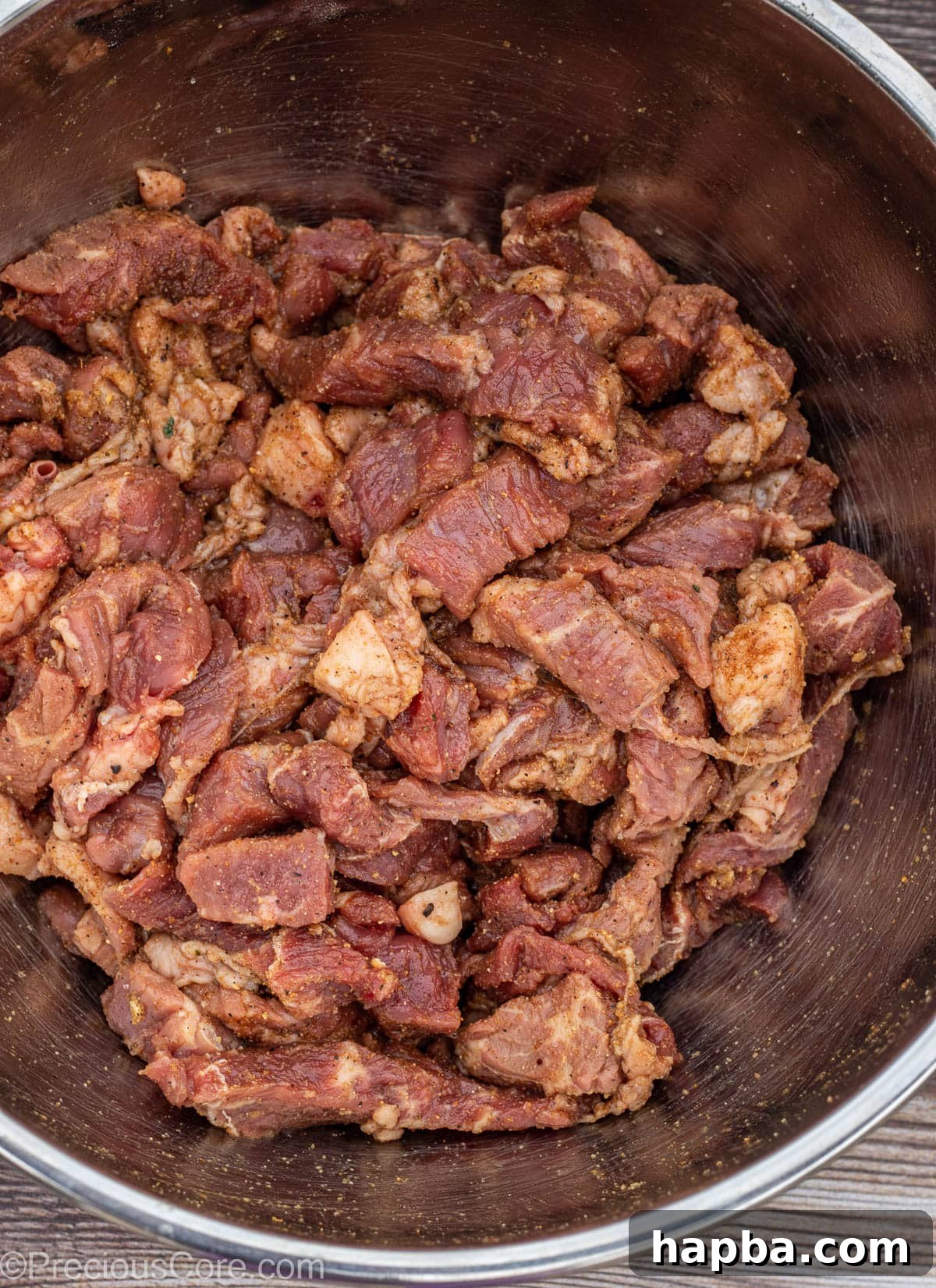 Cameroonian Soya Morsels 6 Seasoned bite-sized pieces of beef in a stainless steel bowl, glistening with spices.