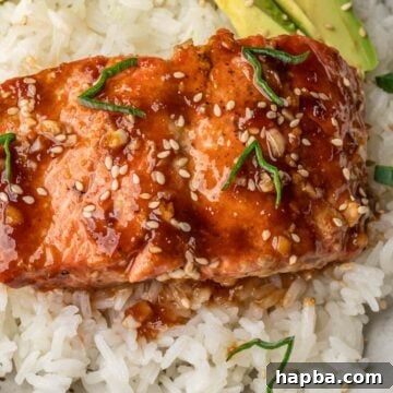 Teriyaki Salmon over rice with avocado slices in a bowl.
