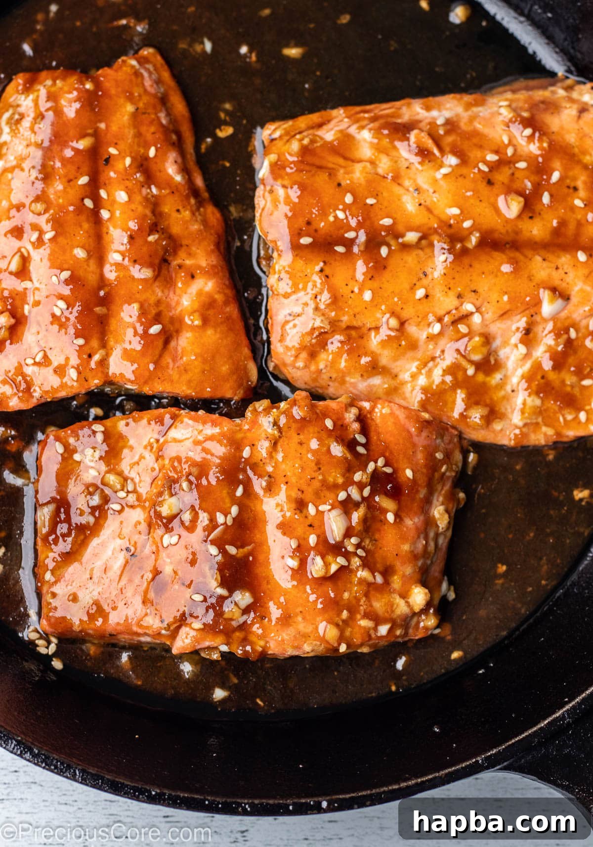 Pan fried teriyaki salmon in cast iron skillet.