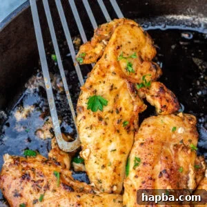 Spatula holding a cooked chicken tenderloin.