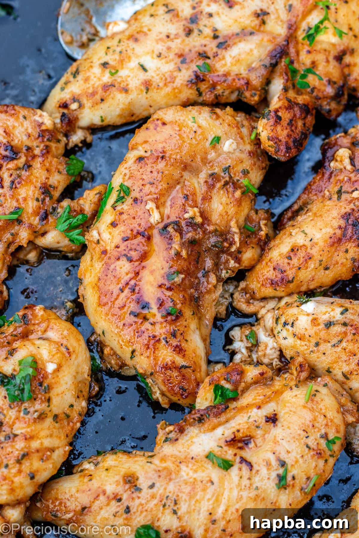 Crispy Pan-Seared Chicken Tenders 3 Golden-brown pan-cooked chicken tenderloins glistening with melted butter in a skillet.