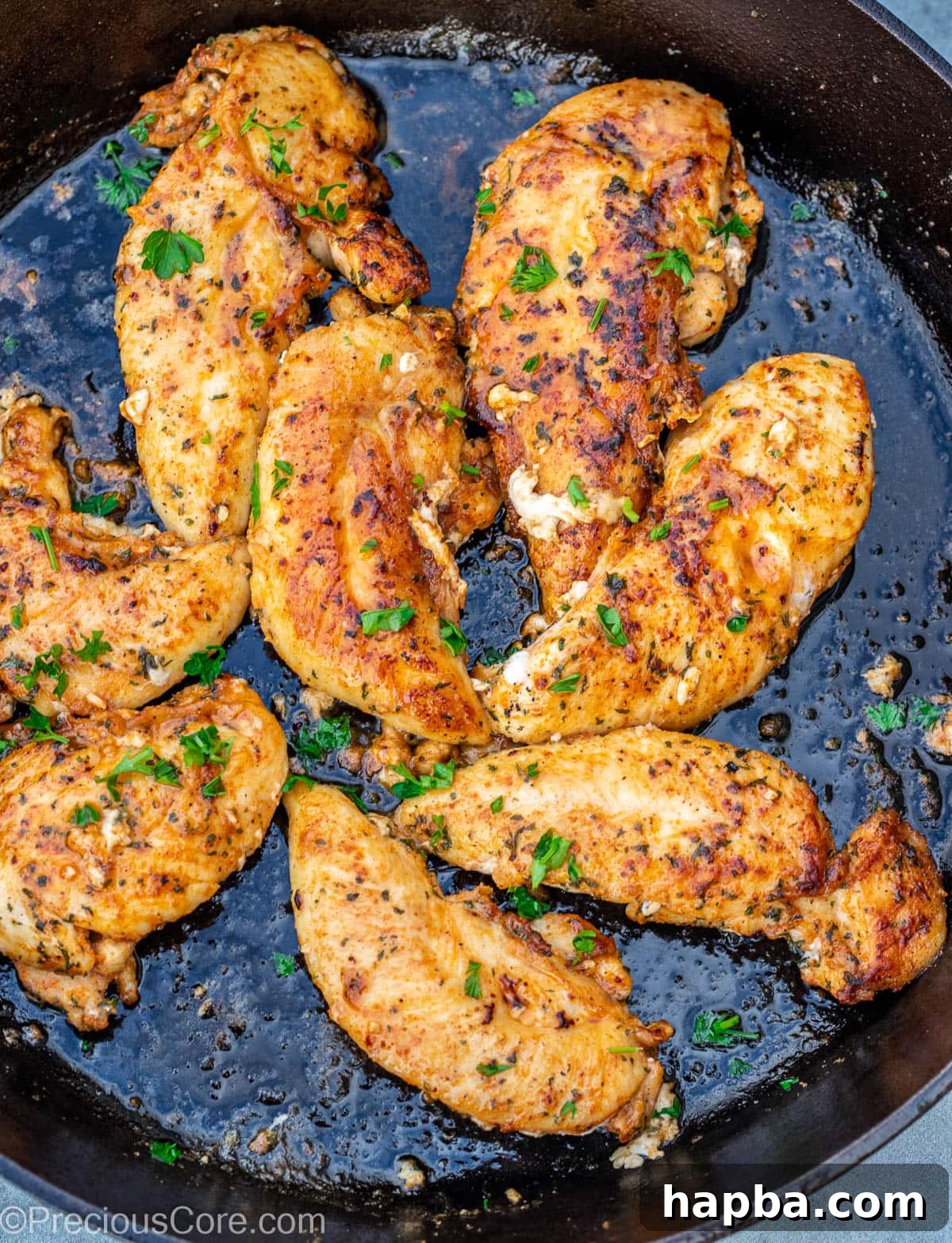 Crispy Pan-Seared Chicken Tenders 7 Chicken tenderloins cooking to a golden perfection in a cast iron skillet.