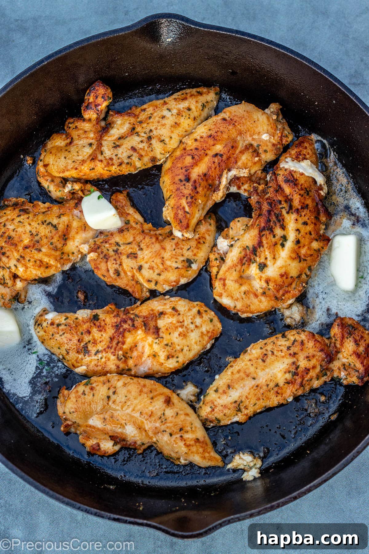 Crispy Pan-Seared Chicken Tenders 8 Melted butter being spooned over perfectly pan-seared chicken tenders in the skillet.