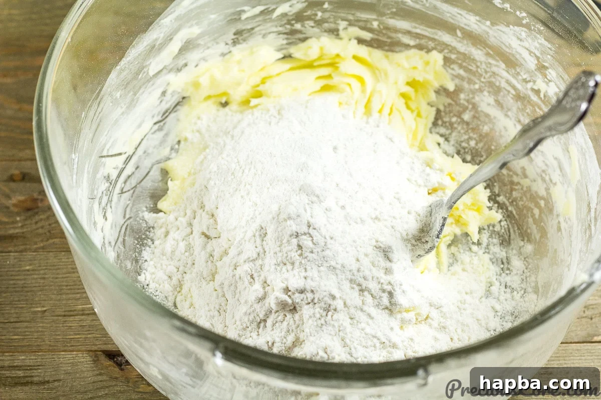 Adding flour to butter and sugar.