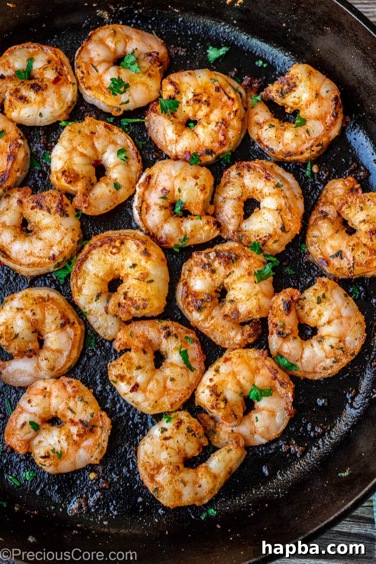 Perfectly pan seared shrimp cooking in a skillet.