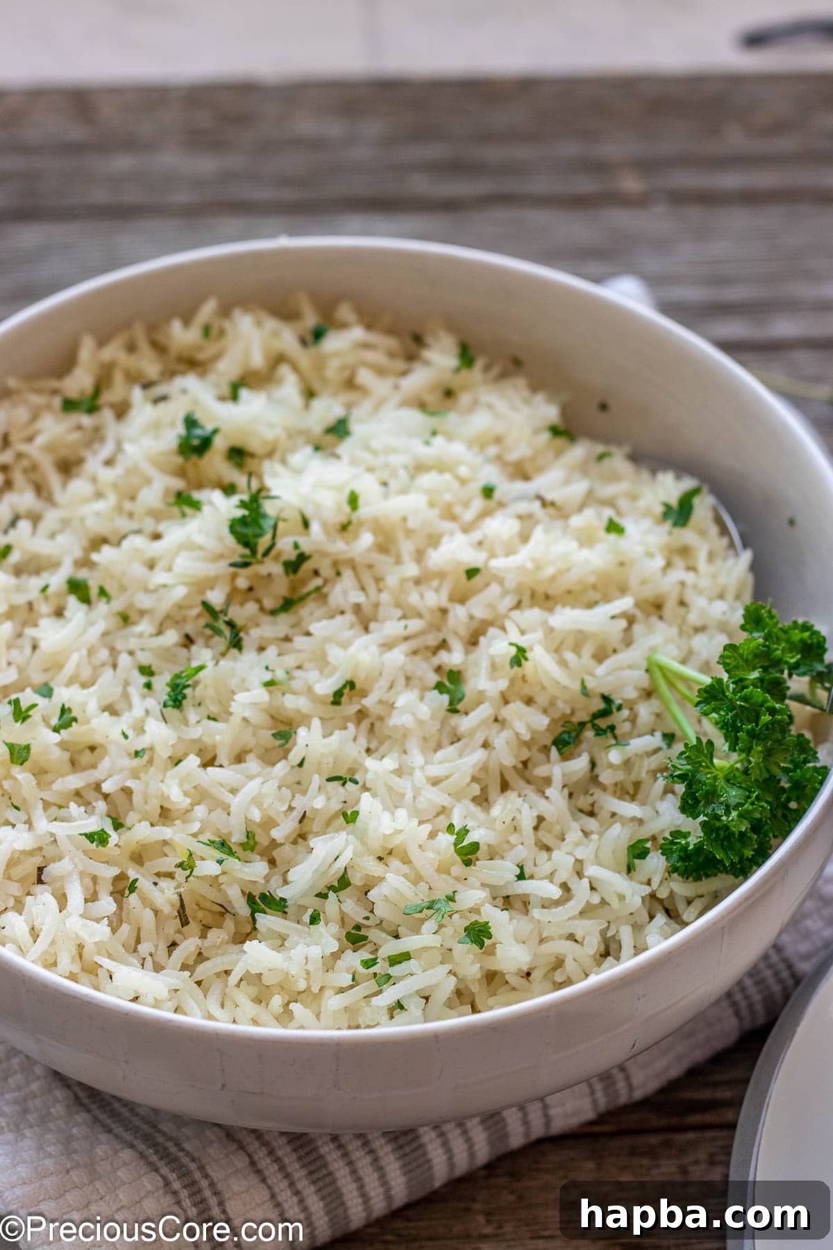 A bowl of fluffy garlic herb rice topped with vibrant minced fresh parsley, ready to be served.