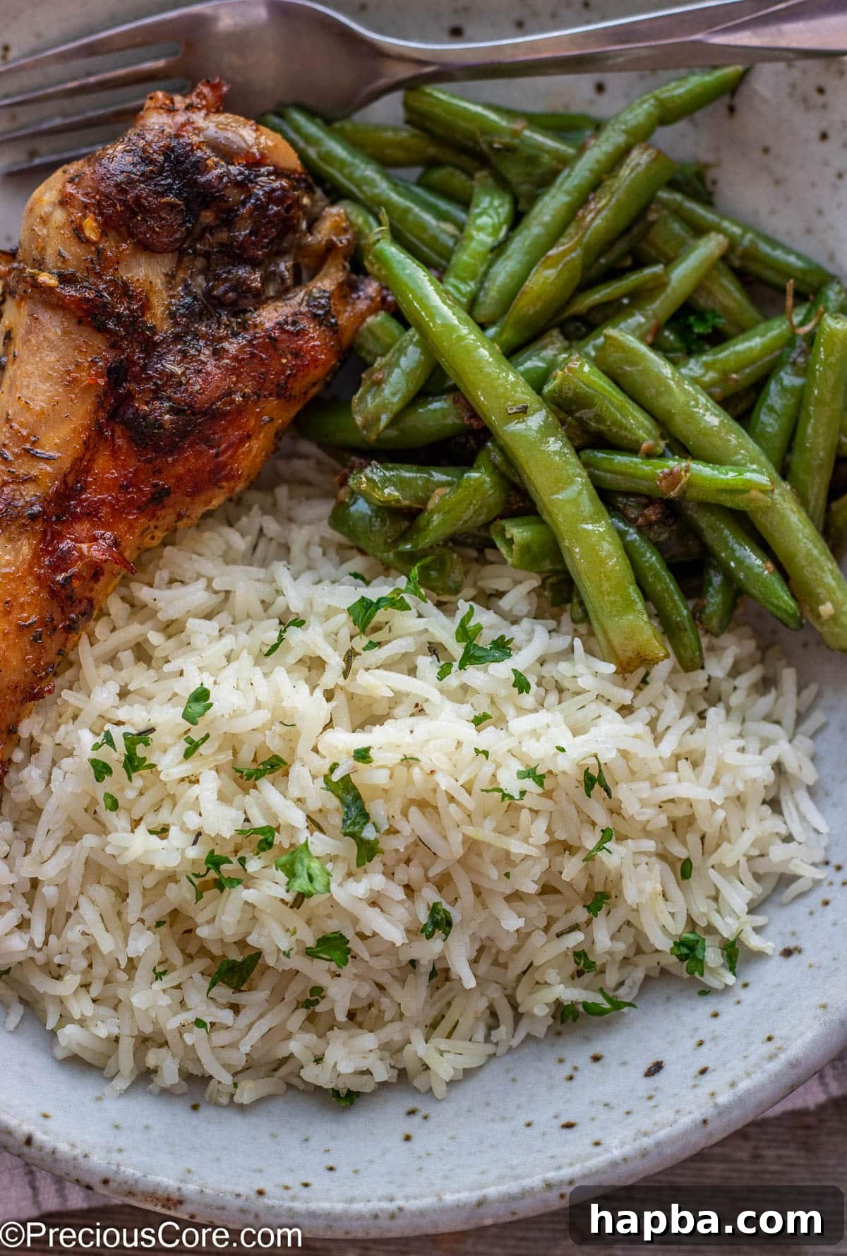 A beautifully plated meal featuring garlic herb rice, tender green beans, and roasted turkey, showcasing its versatility as a side dish.
