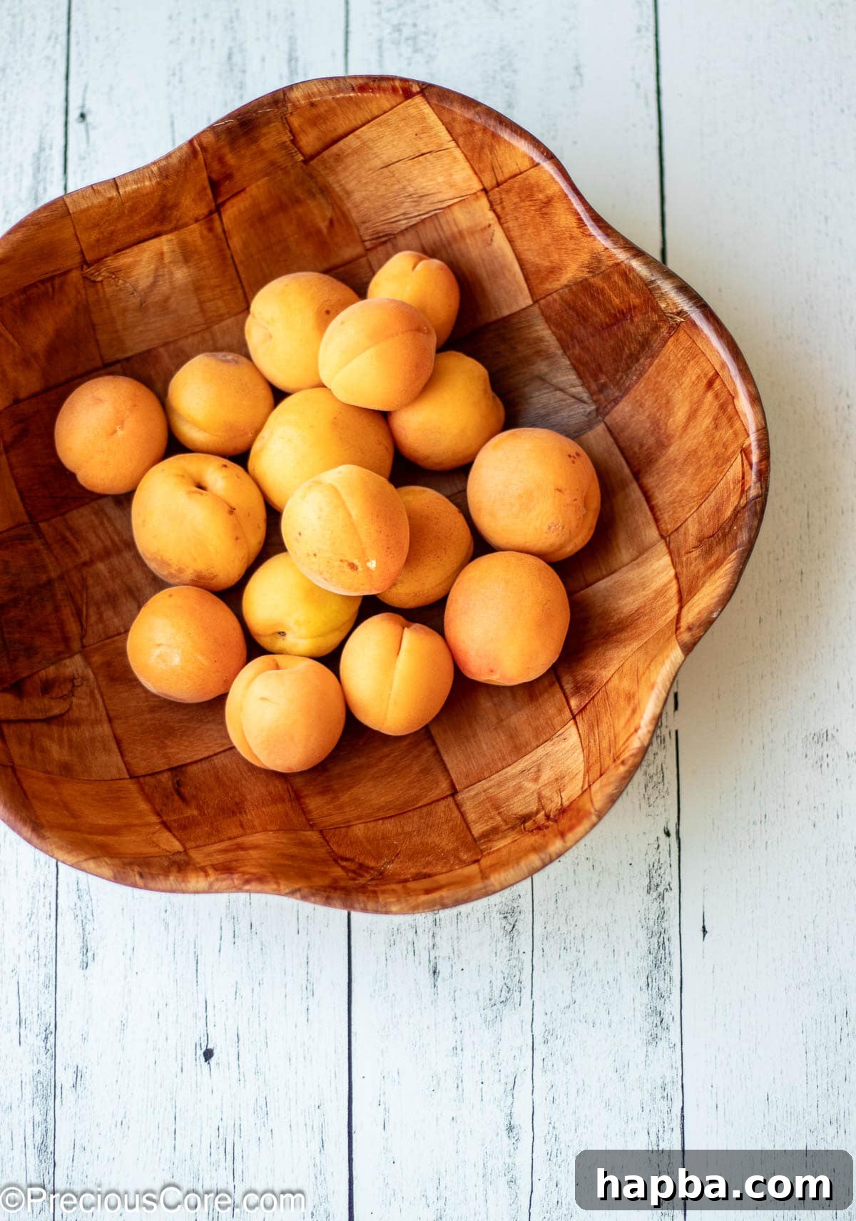 Sunshine Apricot Spread 13 A rustic wooden bowl brimming with fresh, ripe apricots, highlighting their natural beauty.