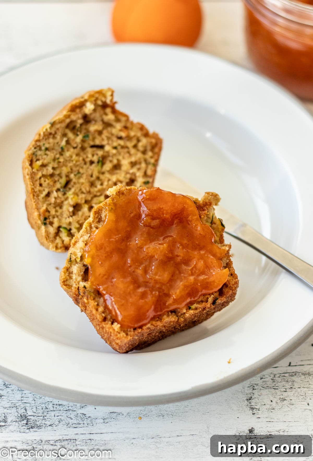 Sunshine Apricot Spread 3 A delicious zucchini muffin split in half, generously spread with homemade apricot preserves.