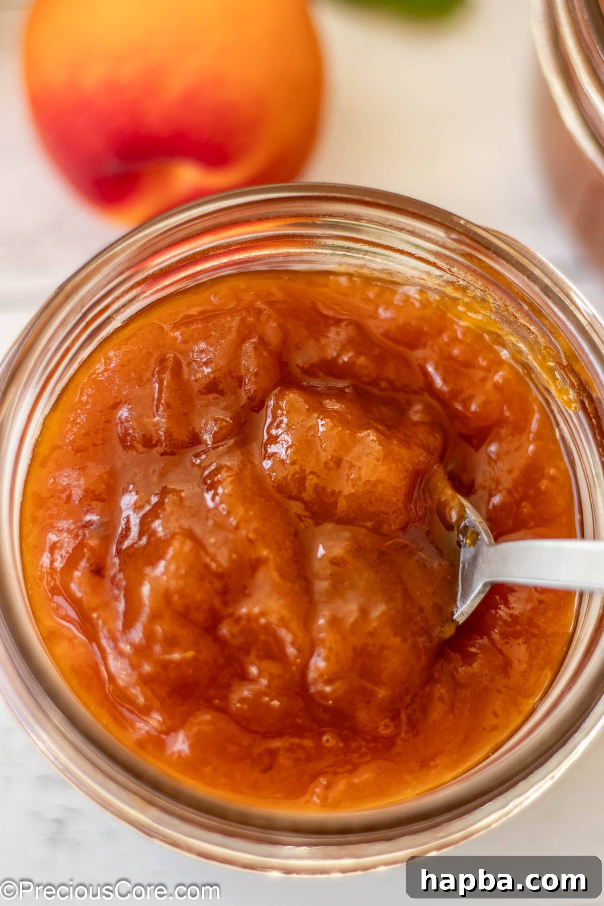Sunshine Apricot Spread 5 A close-up shot of rich, golden apricot preserves in a clear mason jar, highlighting their delicious texture.