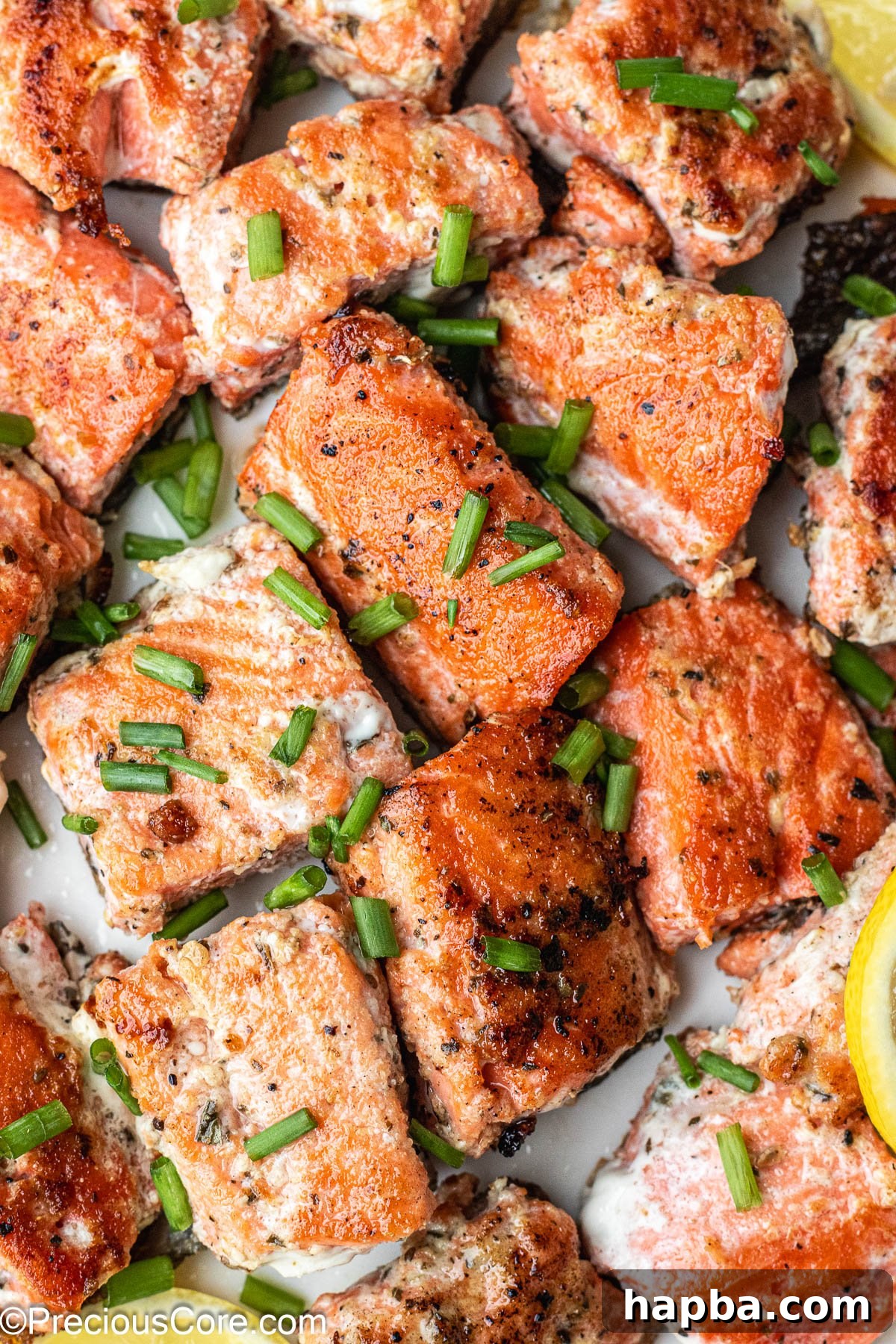 About 1-inch sized salmon bites on a white plate.
