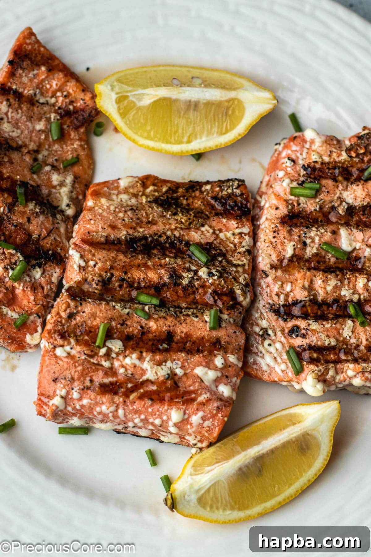 Grilled Sockeye Salmon steaks on a white plate, showcasing beautiful grill marks and a vibrant color.