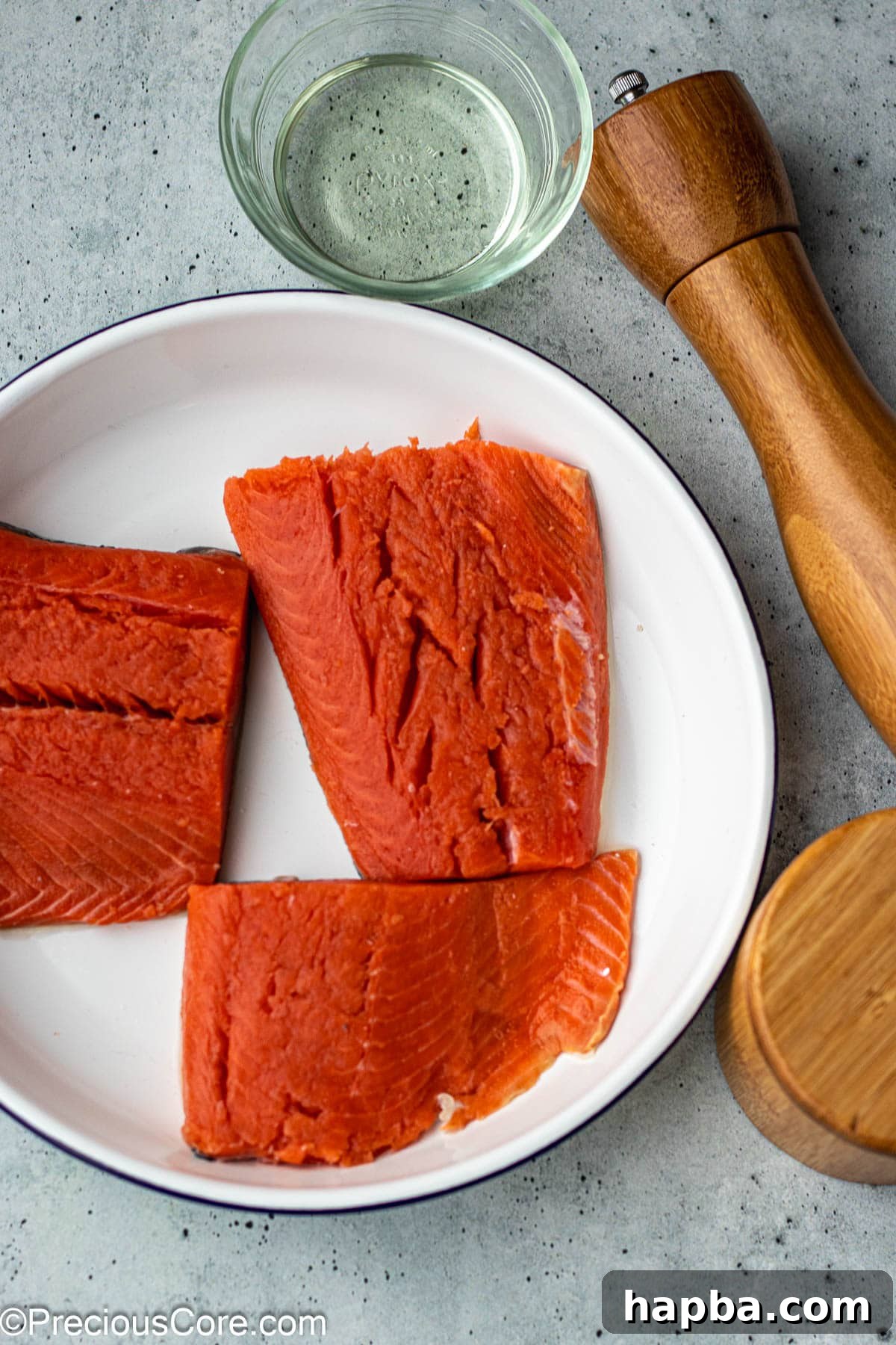 Fresh sockeye salmon fillets, coarse salt, freshly ground black pepper, and a bottle of olive oil.