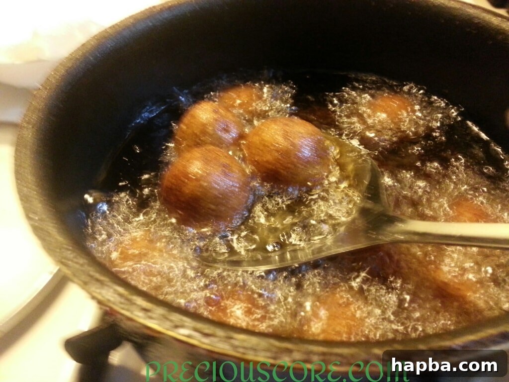 Golden brown Accra Banana fritters being removed from the hot oil.