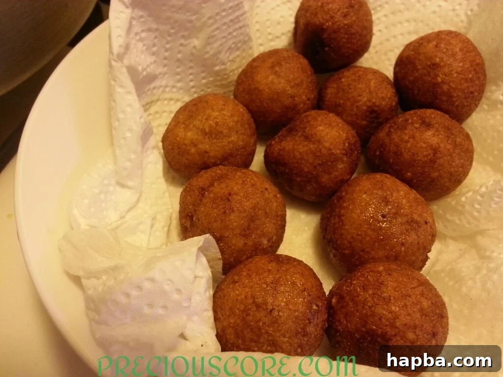 Freshly fried Accra Banana fritters draining on paper towel, ready to be served.