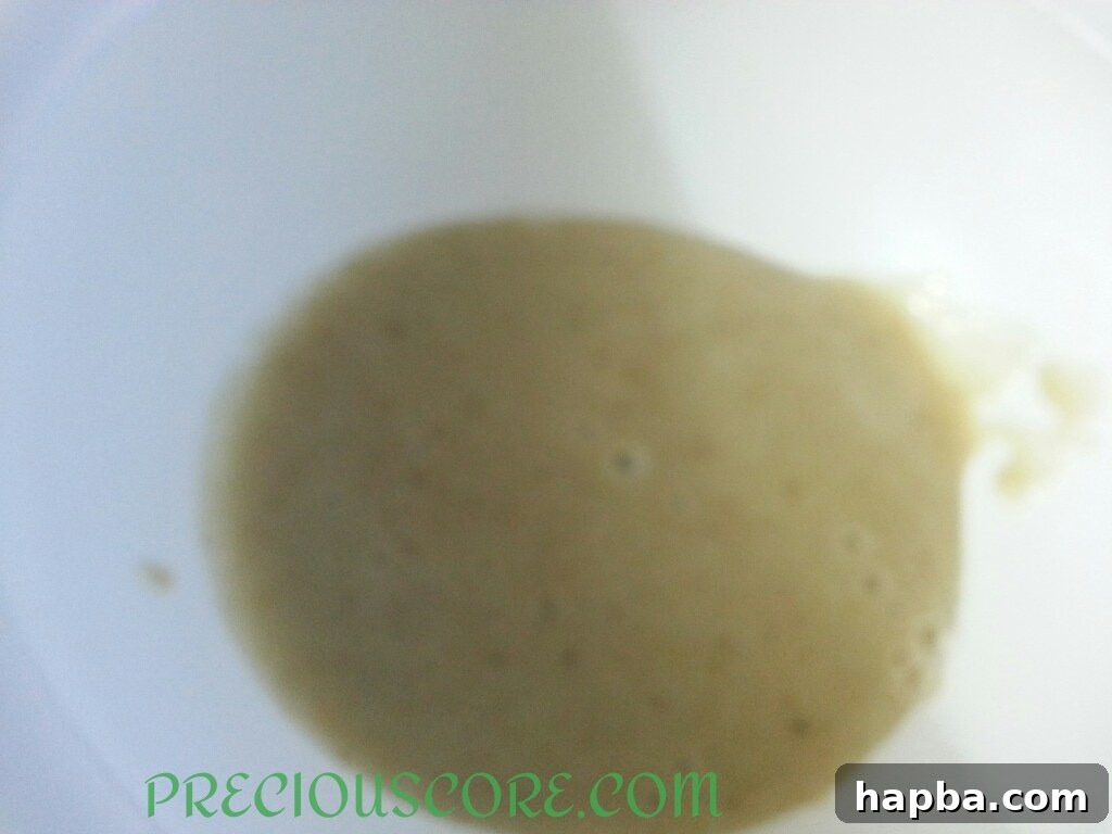 Banana mixture in a bowl, showing the slight darkening due to oxidation, ready for mixing.