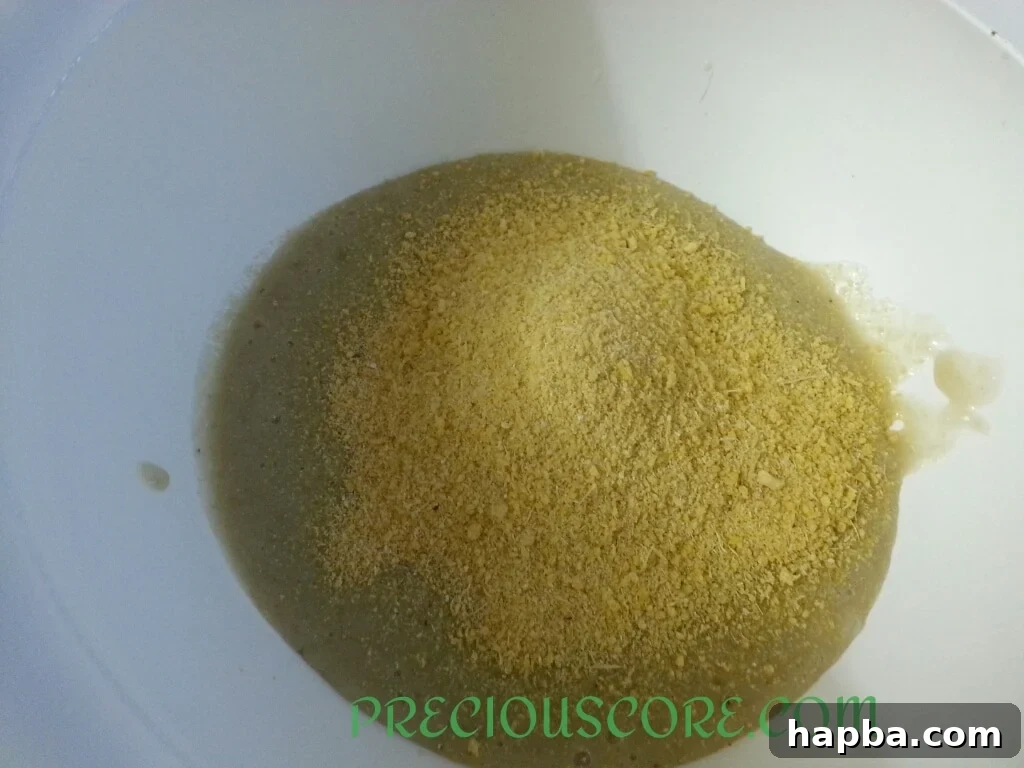 Garri and salt being added to the banana paste in a mixing bowl.