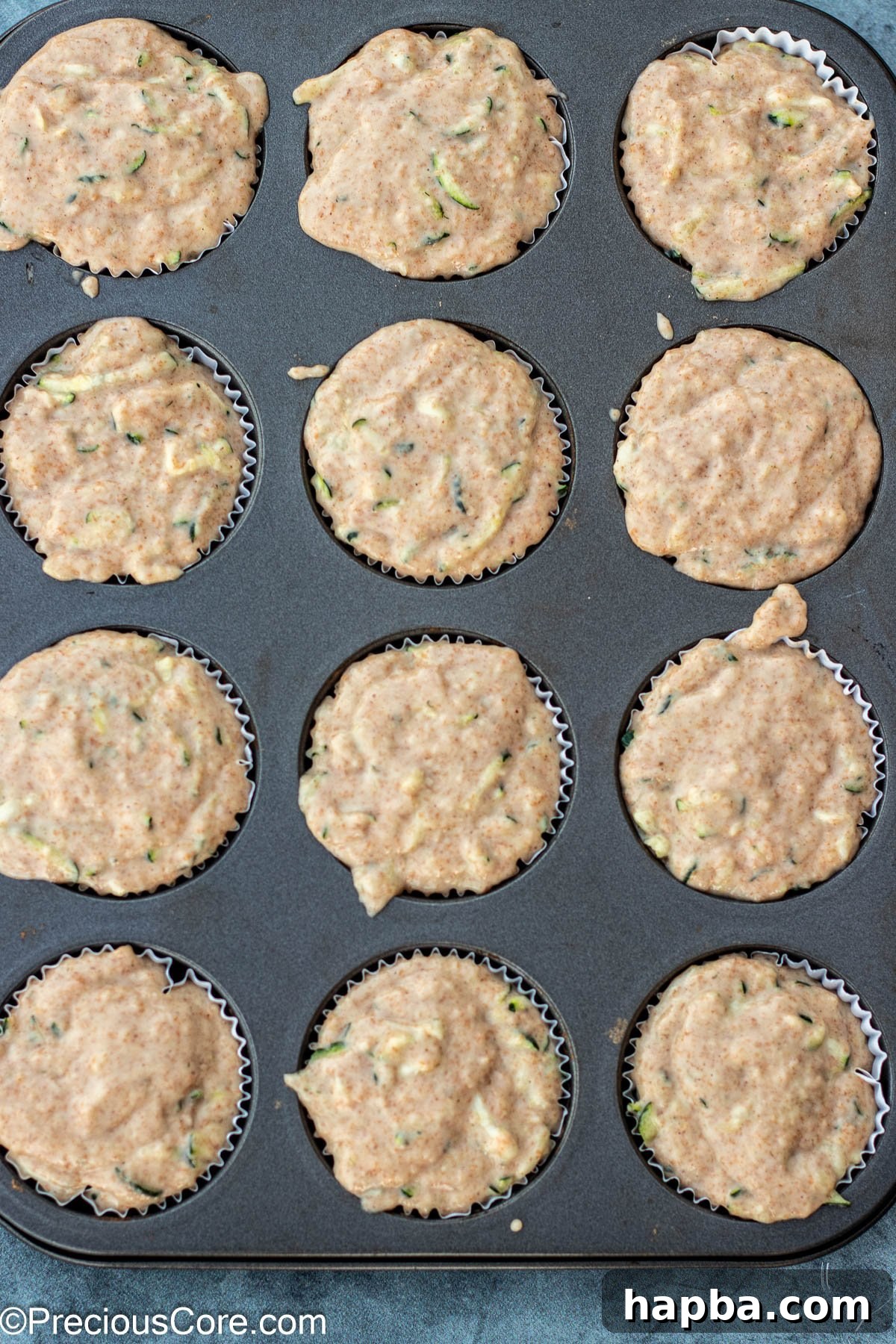 Wholesome Zucchini Applesauce Muffins 11 Zucchini muffin batter portioned neatly into a muffin tin, ready for the oven.