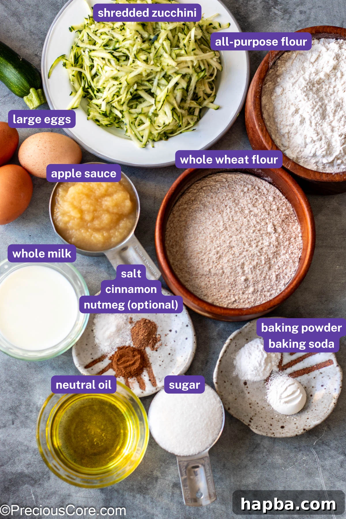 Wholesome Zucchini Applesauce Muffins 4 Various ingredients for zucchini muffins laid out on a table, including flour, sugar, applesauce, oil, eggs, and shredded zucchini.