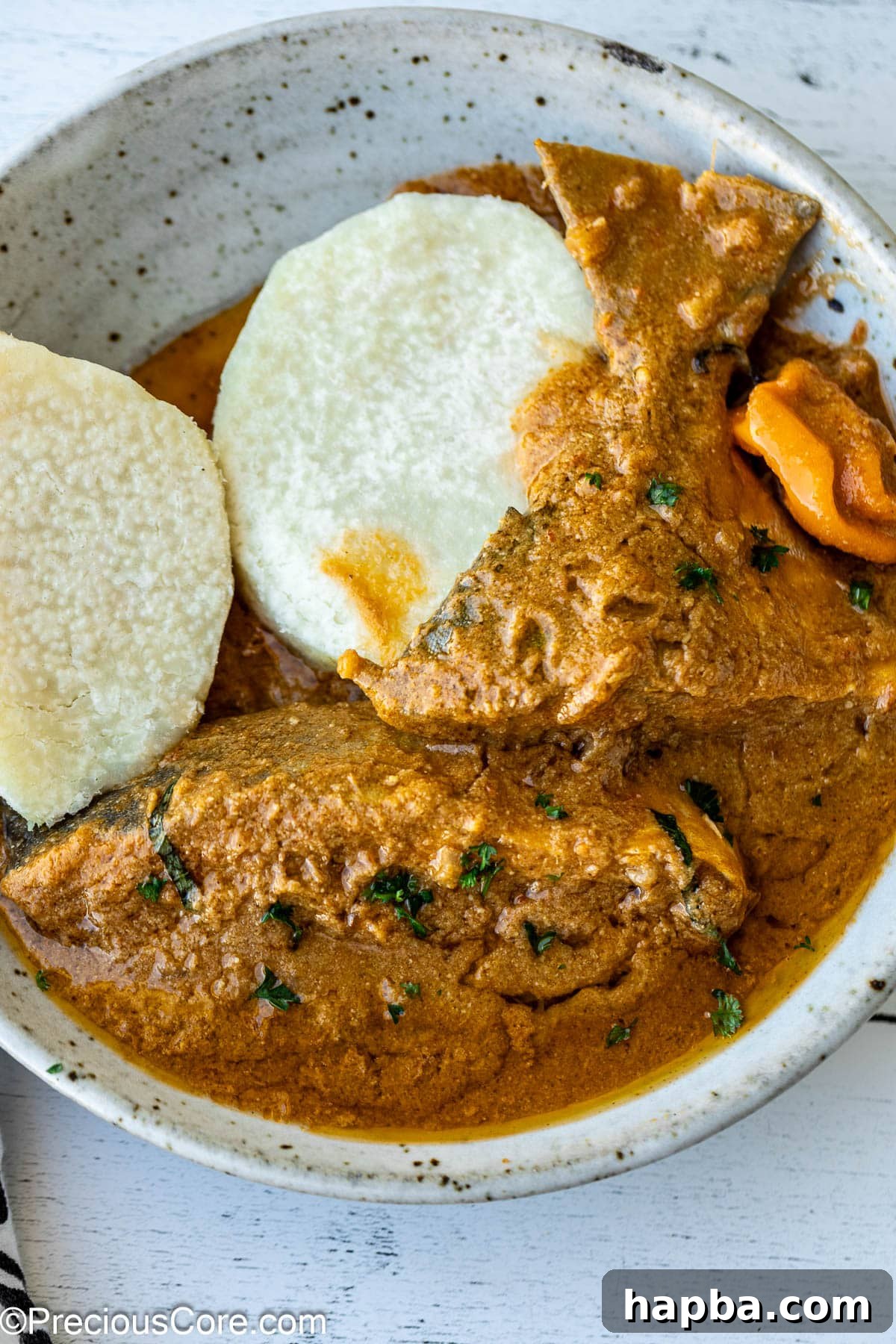 A bowl of creamy Njangsa sauce served alongside tender white yams, ready to be enjoyed.