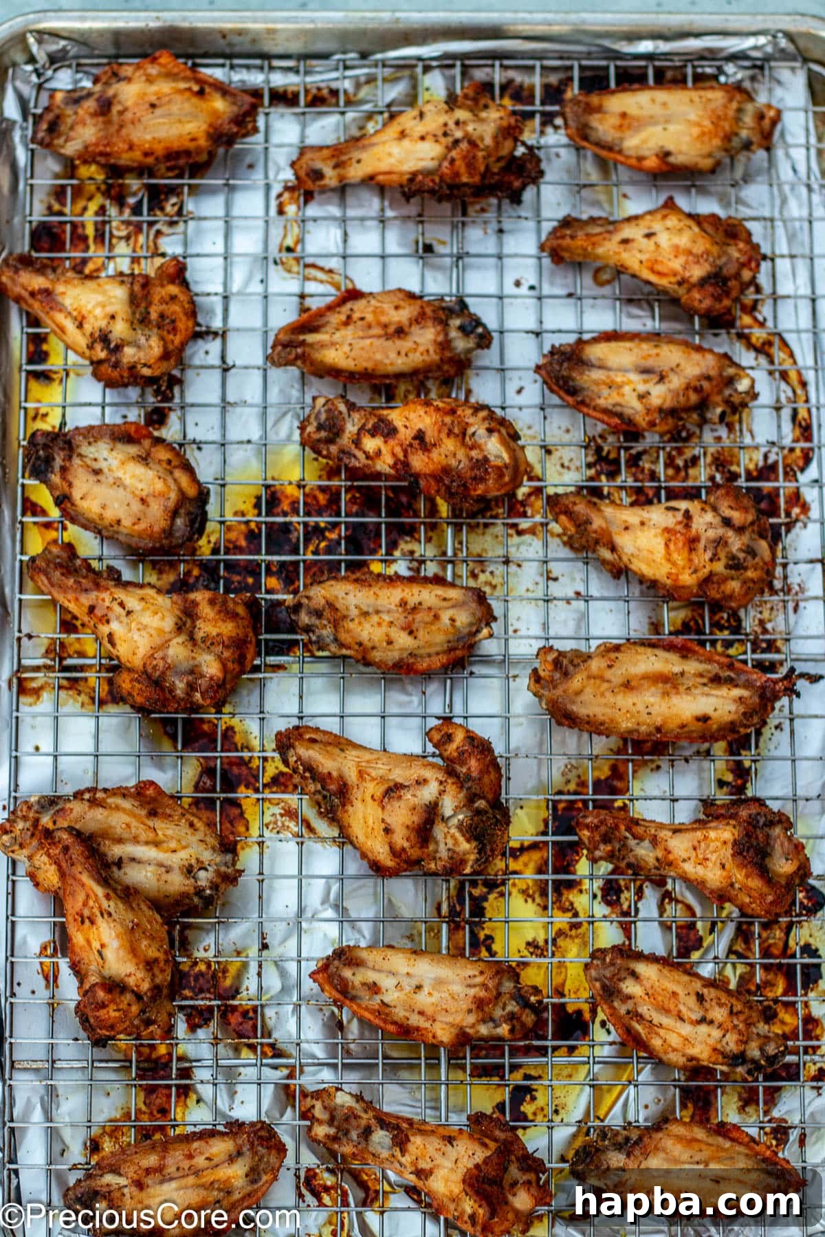 Crispy Baked Dry Rub Wings 7 Freshly baked dry rub chicken wings, golden and crispy, cooling on an oven-safe rack.