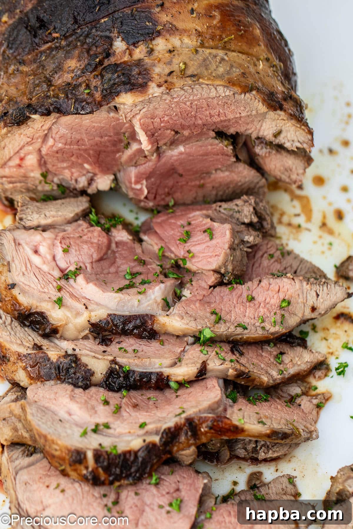 Succulent Boneless Roast Lamb 2 A perfectly sliced roasted boneless leg of lamb, revealing its juicy interior.